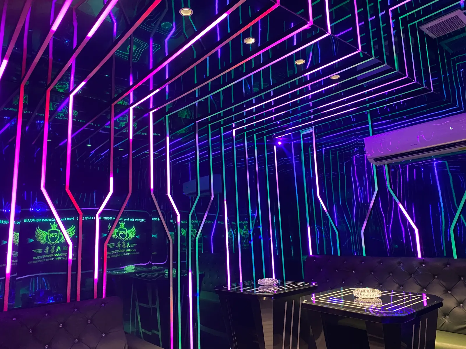 Private KTV room with a mirrored ceiling and multicoloured LED strip lighting